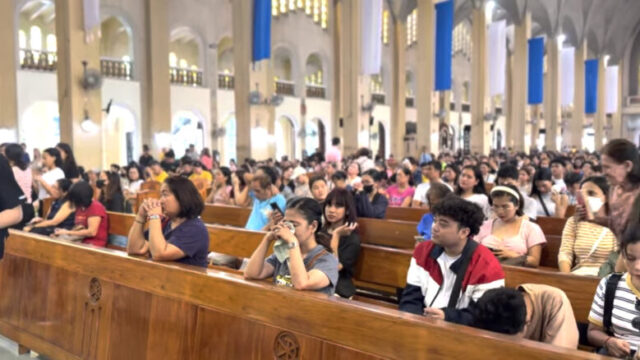 フィリピンの教会で祈る人